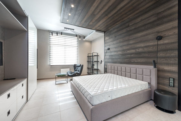 Medium-firm mattress on a bed frame, chosen to support the lower back and keep the spine aligned during sleep